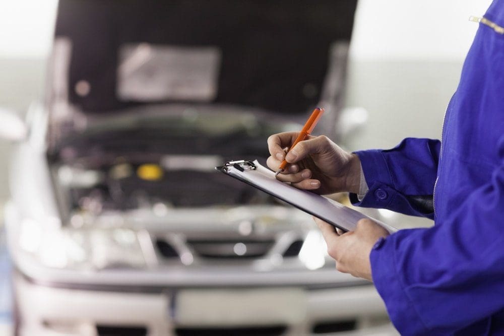 car and mechanic with clipboard