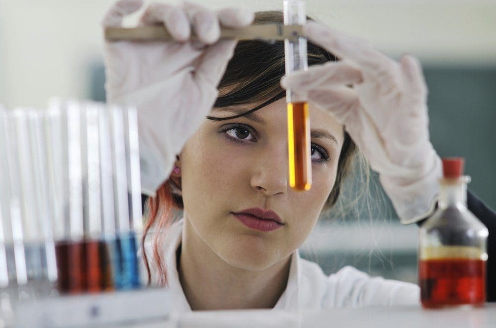 chemist with chemicals in test tubes